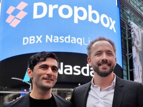 Dropbox co-founders Arash Ferdowski, left, and Drew Houston pose for photos outside the Nasdaq MarketSite, during their company's IPO, in New York's Times Square, Friday.