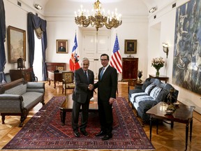 Chile's President Sebastian Pinera, left, and United States Treasury Secretary Steven T. Mnuchin pose for a photo shaking hands at La Moneda presidential palace in Santiago, Chile, Wednesday, March 21, 2018.