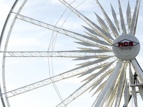 FILE - In this Nov. 10, 2010 file photo, a lone worker is dwarfed by the beams of a ride as he and others dismantle a large ferris wheel at the Arizona State Fairgrounds midway after the close of the annual fair in Phoenix. Arizona officials say they're holding a public session on the future use of the state's aging fairgrounds. The Arizona Exposition and State Fair Board, the state's historic preservation office and the governor's office will hold the first meeting Thursday, March 8, 2018, in the coliseum at the fairgrounds in downtown Phoenix.