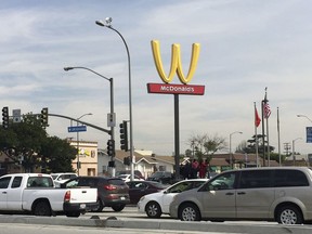 Motorists make their way past a McDonald's restaurant with a flipped Golden Arches sign Thursday, March 8, 2018, in Lynwood, Calif. McDonald's has temporarily flipped its famous Golden Arches to look like a "W," a move it says it made to recognize International Women's Day.