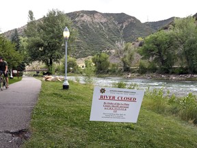 FILE –  In this Aug. 11, 2015 file photo, a La Plata County sheriff notice marks the closure of the Animas River due to the Gold King Mine spill downstream from the mine, in Durango, Colo. The EPA says it has almost finished reviewing hundreds of damage claims from the spill, but the agency has still not released a clear accounting of the claims made for economic losses and personal injuries.