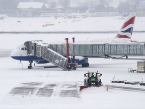 The fire brigade of Airport Security Services (SSA) ride a snowplow removing snow on the runway at the Geneva Airport, in Geneva, Switzerland, Thursday, March 1, 2018.