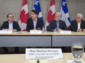 Prime Minister Justin Trudeau, left, speaks at a roundtable meeting with members of the aluminum industry in Saguenay, Que., Monday, March 12, 2018. Saguenay MP Richard Hebert, Quebec Premier Philippe Couillard, centre right, and Dubiuc MNA Serge Simard, right, look on.