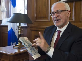 Quebec Finance Minister Carlos Leitao shows a copy of the provincial budget speech at a news conference on the eve of a provincial budget Monday, March 26, 2018 in his Quebec City office.