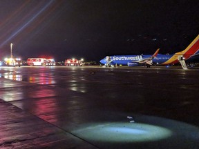 In this Sunday, March 11, 2018 photo, Southwest aircraft flight 3562 sits on the tarmac  after making an emergency landing at Albuquerque International Sunport in Albuquerque, Ariz. The Dallas-bound flight made an emergency landing at the Albuquerque airport, sending panicked passengers leaping from a wing onto the tarmac after crew members screamed at them to get away from the aircraft, passengers and officials said.