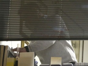 The scene at a window as Information Commissioner's Office enforcement officers work inside the offices of Cambridge Analytica in central London after a High Court judge granted a search warrant, Friday March 23, 2018.  The investigation into alleged misuse of personal information continues Friday to determine whether Cambridge Analytica improperly used data from some 50 million Facebook users to target voters with ads and political messages.