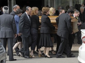 FILE - In this May 18, 2015, file photo, pallbearers carry the casket of Rachel Jacobs, a 39-year-old educational software executive who was among eight passengers killed when an Amtrak train from Washington to New York derailed in Philadelphia on May 12, to a hearse after her funeral service in Southfield, Mich. Gilda Jacobs, Rachel's mother, told a U.S. Senate committee Thursday, March 1, 2018, she is seething over the prospect of more delays in installing speed controls, known as positive train control or PTC, that could've prevented the wreck and dozens of others.