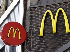 FILE- In this April 24, 2017, photo, corporate signage hangs at a McDonald's restaurant in downtown Pittsburgh. McDonald's announced Tuesday, March 6, 2018, that it is offering fresh beef rather than frozen patties in some burgers at thousands of restaurants, a switch it first announced about a year ago as it works to appeal to customers who want fresher foods.