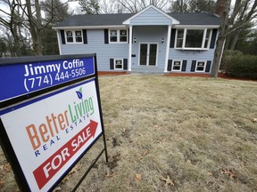 FILE- In this Feb. 23, 2018, file photo a for sale sign stands in front of a house in Walpole, Mass. On Wednesday, March 21, the National Association of Realtors reports on February sales of existing homes.