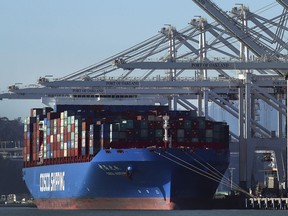 FILE- In this Jan. 30, 2018, file photo, a container ship waits to be unloaded at the Port of Oakland in Oakland, Calif. The Commerce Department reports on the U.S. trade gap for January, on Wednesday, March 7.