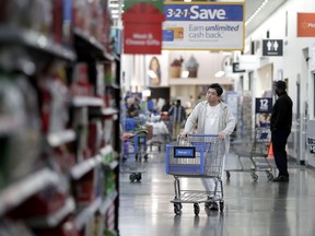 FILE- In this Nov. 9, 2017, file photo, a man pushes a cart while shopping at a Walmart store in North Bergen, N.J. On Thursday, March 29, 2018, the Commerce Department issues its February report on consumer spending.