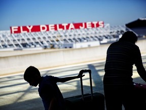 FILE- In this Oct. 13, 2016, file photo, passengers unload in front of a Delta Air Lines sign at Hartsfield-Jackson Atlanta International Airport, in Atlanta. Georgia lawmakers punished Atlanta-based Delta Air Lines on Thursday, March 1, 2018, for its decision to cut business ties with the National Rifle Association in the wake of a shooting at a Florida high school that killed over a dozen people. A tax measure, which was stripped of a jet-fuel tax break, passed the GOP-dominated Senate 44-10.