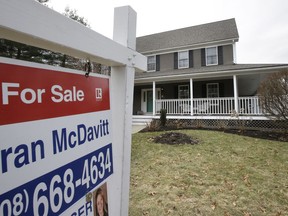 In this Friday, Feb. 23, 2018, photo a for sale sign stands in front of a house, in Walpole, Mass. Freddie Mac reports on the week's average U.S. mortgage rates on Thursday, March 15.