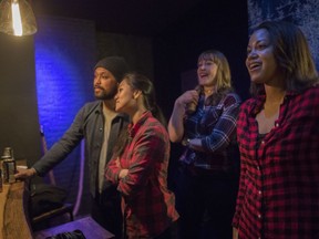 In this Saturday, March 3, 2018, photo, contestants watch as others throw hatchets at the Kick Axe Throwing venue in the Brooklyn borough of New York. Kick Axe Throwing is the first bar in New York City to pick up on a nationwide trend of ax throwing.