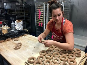 In this Friday, March 23, 2018, photo, Katie Chaisson, a baker at the Psychedelicatessen bagel bistro, makes hand-rolled bagels in Troy, N.Y. Chaisson said she would like to save for retirement through a state-facilitated payroll deduction plan proposed by Democratic Gov. Andrew Cuomo and under consideration by the Legislature.