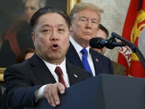 FILE - In this Thursday, Nov. 2, 2017, file photo, Broadcom CEO Hock Tan speaks while U.S. President Donald Trump listens, in background, during an event at the White House in Washington, to announce the company is moving its global headquarters to the United States. In a decision announced Monday, March 12, 2018, Trump is blocking Singapore chipmaker Broadcom from pursuing a hostile takeover of U.S. rival Qualcomm on the grounds that the combination would threaten national security.