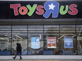 File- This Jan. 24, 2018, file photo shows a person walking near the entrance to a Toys R Us store, in Wayne, N.J.  Toys R Us's management has told its employees that it will sell or close all of its U.S. stores. That's according to a toy industry analyst who spoke to several employees who were on the call Wednesday, March 14, 2018. Jim Silver, a toy industry expert, says Toys R Us's CEO told employees the plan is to liquidate all of its U.S. stores and after that, it could do a deal with its Canadian operation to run some of its U.S. stores. The company declined to comment.