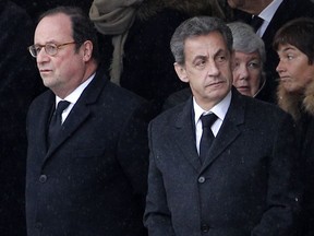 Former French Presidents Francois Hollande, left, and Nicolas Sarkozy wait prior to a national ceremony for Lt. Col. Arnaud Beltrame, Wednesday March 28, 2018 at the Hotel des Invalides in Paris. The slain hero of last week's extremist attack in southern France will be posthumously awarded the Legion of Honor by French President Emmanuel Macron during a solemn day-long national homage to him.