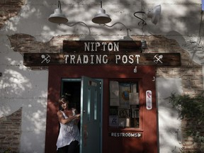 FILE - In this Aug. 3, 2017, file photo, a woman leaves the Nipton Trading Post in Nipton, Calif. A Phoenix-based marijuana technology company bought the town of Nipton for $5 million with ambitious plans to turn its dusty, nearly deserted 80 acres into a pot-friendly resort destination just an hour outside Las Vegas. But the company announced earlier in March 2018 it has sold Nipton to Delta International Oil & Gas in a cash and stock deal worth about $7.7 million.