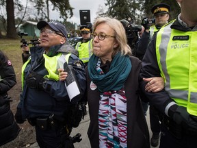 Federal Green Party Leader Elizabeth May, centre, is arrested by RCMP officers after joining protesters outside Kinder Morgan's facility in Burnaby, B.C., on March 23.
