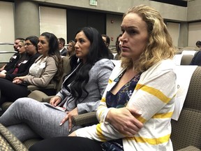 Renee Wetzel, right, whose husband died in the 2015 San Bernardino terrorist attack, watches as fellow family members of mass shooting victims call on California's public pension fund to stop investing in retailers that sell assault weapons in Sacramento, Calif., on Monday, March 19, 2018. Wetzel testified before the board urging them use her husband's memory to make change, adding "let California say 'no more.'"