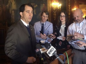 FILE - In this Feb. 14, 2018, file photo, Wisconsin Gov. Scott Walker, speaks to reporters in Madison, Wis. Walker could barely contain himself with the news Thursday, March 22, 2018, that Wisconsin's unemployment rate hit a new record low of 2.9 percent. Walker, who is up for re-election in November, sent a combined 17 tweets on both his official and political Twitter accounts crowing about the news, sometimes with smiling sunglass-wearing emojis, once again referencing one of his favorite pop songs from the 1980s: "Future's so bright, I gotta wear shades!"