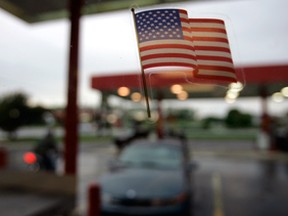 A U.S. flag stuck on a window at a gas station in Marietta, Pa. The United States, once the world’s top oil importer, is moving closer to self sufficiency.