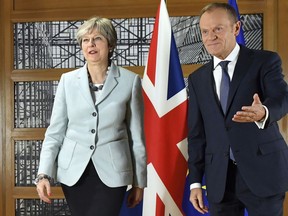FILE - In this Dec. 8, 2017 file photo, British Prime Minister Theresa May, left, walks with European Council President Donald Tusk in Brussels. European Council President Donald Tusk unveiled on Wednesday, March 7, 2018, the EU's approach to the next phase of Brexit talks on future relations with the UK.