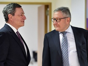 European Central Bank President Mario Draghi, left, speaks with Managing Director of the European Stability Mechanism Klaus Regling during a meeting of the eurogroup at the EU Council building in Brussels on Monday, March 12, 2018.