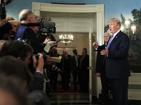 President Donald Trump with, Vice President Mike Pence, responds to reporters' questions in the Diplomatic Room of the White House in Washington, Friday, March 23, 2018, after he spoke about the $1.3 trillion spending bill he signed earlier in the day.