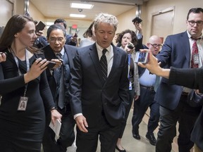 In this March 21, 2018, photo, Sen. Rand Paul, R-Ky., walks to the Senate floor for a vote with accompanying reporters, on Capitol Hill in Washington. As the Senate gets closer to another government funding deadline, Paul is protesting the pending $1.3 trillion spending bill, which he has called "budget-busting."