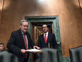FILE - In this Jan. 30, 2018, file photo, Senate Banking Committee Chairman Sen. Mike Crapo, R-Idaho, second from left, arrives with Treasury Secretary Steven Mnuchin, right, at the Senate Banking Committee on Capitol Hill in Washington. Ten years after the financial crisis rocked the nation's economy, the Senate is poised to pass legislation that would roll back some of the safeguards Congress put into place to prevent a relapse. The Senate bill emerged from lengthy negotiations between Crapo and Democratic members on the committee. The ranking Democrat, Sen. Sherrod Brown of Ohio, said the changes go too far and he walked away.