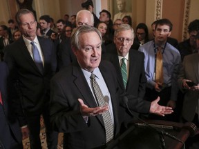 FILE - In this March 6, 2018, file photo, Sen. Mike Crapo, R-Idaho, chairman of the Senate Banking Committee, joined by, Sen. John Thune, R-S.D., left, and Senate Majority Leader Mitch McConnell, R-Ky., right, talks to reporters as the Senate moves closer to passing legislation to roll back some of the safeguards Congress put in place to prevent a repeat of the 2008 financial crisis, at the Capitol in Washington. Burrowed within new Senate legislation to roll back restraints on banks is a break from data reporting requirements for lenders making certain levels of mortgage loans.