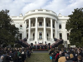 FILE - In this Dec. 20, 2017, file photo, President Donald Trump, surrounded by members of congress and supporters, speaks during an event on the South Lawn of the White House in Washington, to acknowledge the final passage of tax overhaul legislation by Congress. The new tax law ends a benefit long prized by business for schmoozing with customers or courting new ones. And the impact could be felt in big glitzy boxes at sports stadiums, or even at minor league games in small towns with loyal company backers.
