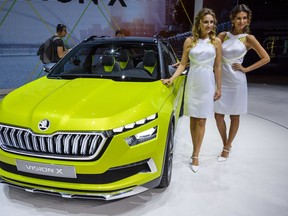 Two hostess pose next to the new Skoda Vision X, during the press day at the 88th Geneva International Motor Show in Geneva, Switzerland, Tuesday, March 6, 2018. The Motor Show will open its gates to the public from March 8 to March 18  presenting more than 180 exhibitors and more than 110 world and European premieres.
