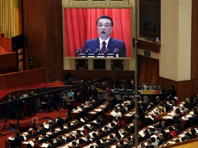Chinese Premier Li Keqiang is shown on a large screen as he delivers a work report at the opening session of the annual National People's Congress in Beijing's Great Hall of the People, Monday, March 5, 2018.