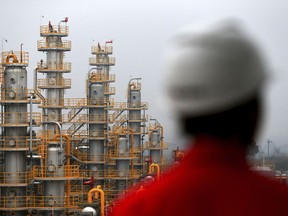 In this Jan. 22, 2016 photo, a worker stands at a natural gas plant owned by China's state-owned enterprise PetroChina in Suining in southwestern China's Sichuan province. Businesspeople are looking to China's ceremonial legislature for assurance President Xi Jinping is speeding up reforms aimed at making the cooling economy more productive as he prepares the country for a return to one-man rule.(Chinatopix via AP)