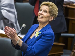 Ontario Premier Kathleen Wynne applauds while Ontario Finance Minister Charles Sousa (not pictured) delivers the provincial budget at the Ontario Legislature in Toronto, March 28, 2018.