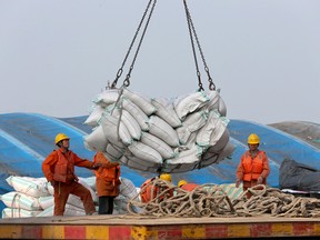 Workers load imported soybeans at a port in Nantong in east China's Jiangsu province.