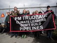 Federal Green Party Leader Elizabeth May, centre left, and NDP MP Kennedy Stewart, left, stand with protesters before they were arrested outside Kinder Morgan's facility in Burnaby, B.C., on Friday March 23, 2018.