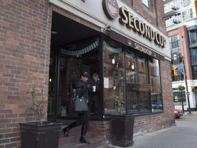 A customer carries her coffee as she leave a Second Cup shop.