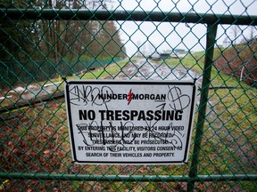 A "No Trespassing" sign is displayed on a fence outside of the Kinder Morgan Inc. facility in Burnaby, British Columbia.