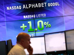 In this Monday, Feb. 1, 2016, file photo, electronic screens post the price of Alphabet stock at the Nasdaq MarketSite in New York.