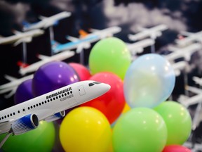 A model of a Bombardier CSeries jet among promotional balloons.