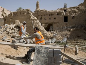 In this March 8, 2018 photo, workers restore the Al Sarreha Mosque in the 18th century Diriyah fortified complex, that once served as the seat of power for the ruling Al Saud, in Riyadh, Saudi Arabia. The UNESCO World Heritage site lies in a conservative, arid patch of the country and is unlikely to feature high on any bucket lists for world travelers, but the kingdom is hoping to alter perceptions as it prepares to open the country to tourist visas and international tour groups later this year.