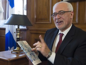 Quebec Finance Minister Carlos Leitao holds a copy of the provincial budget speech.