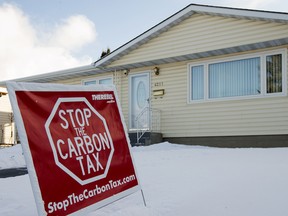 An anti carbon tax sign is posted in the front lawn of a home in Edmonton.