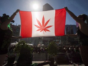 Two people hold a modified design of the Canadian flag with a marijuana leaf in in place of the maple leaf during the "4-20 Toronto" rally in Toronto, April 20, 2016.