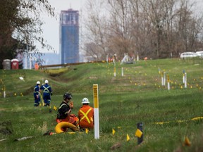 Two workers talk as flags mark an underground pipeline location as work continues at Kinder Morgan's facility in preparation for the expansion of the Trans Mountain Pipeline, in Burnaby, B.C., on April 9, 2018. Details are expected to be released today about British Columbia's court case that questions if the province has the power to regulate the flow of oil from the Trans Mountain pipeline expansion. Premier John Horgan has said a reference case will be filed in B.C.'s Court of Appeal by April 30, seeking to clarify the province's rights to protect its environment and economy from an oil spill.