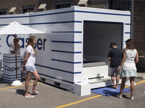 Promotional staff watch a man as he enters a pop-up installation from the mattress company Casper aimed at encouraging the public to use "nap rooms," equipped with their mattresses, in Toronto on Friday August 19, 2016. Casper expanding into Canada with brick and mortar retail shops.